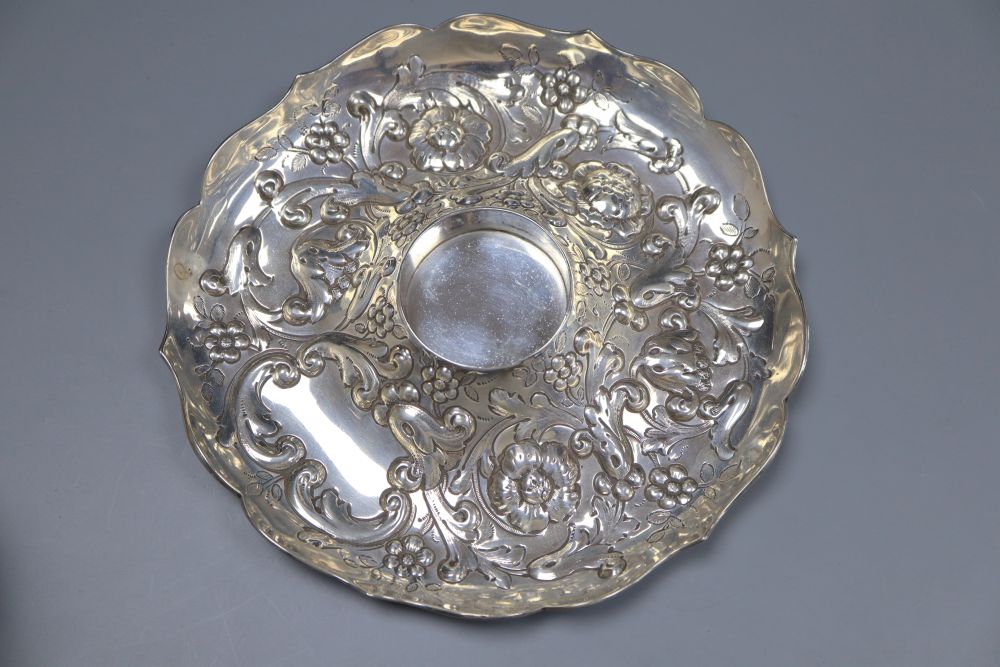 A late Victorian repousse silver mounted glass inkwell, on a repousse silver stand, London, 1891, height 14.4cm.